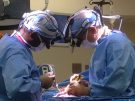 two doctors perform surgery