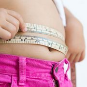 child measuring belly with tape measure