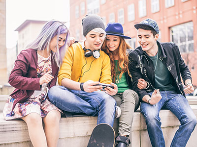 group of teenagers sitting on a wall