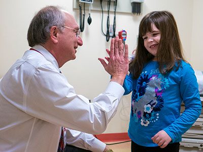 Roger Packer high fives patient Olivia Enos