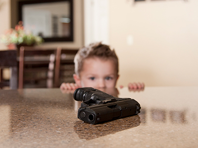 little boy looking at gun