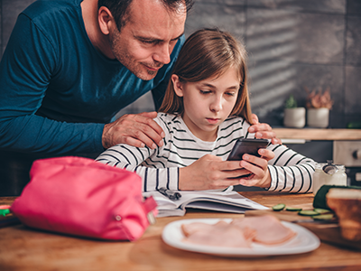 Girl using smartphone with dad