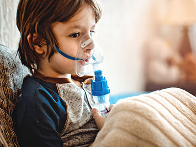 little boy using asthma inhaler