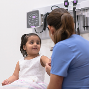 Pediatrician talking with young girl