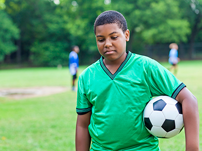 sad boy holding soccer ball