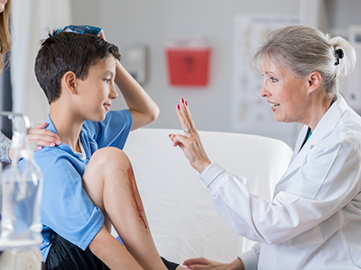 doctor checking boy for concussion