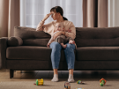 Depressed mom sitting on couch with infant