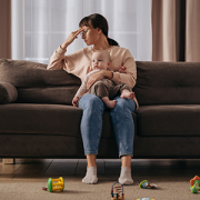Depressed mom sitting on couch with infant