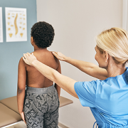 Osteopath examining boy's spine