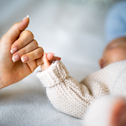 Hand holding newborn baby's hand
