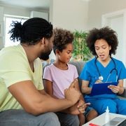 A father and daughter talk to a doctor