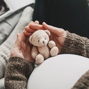 Pregnant teen girl holding small stuffed bear