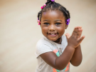 Young girl smiling and clapping