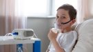 Boy in bed with oxygen mask