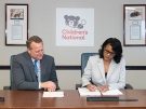 Michelle Riley-Brown, MHA, FACHE, president and CEO of Children’s National, signs the Epic contract