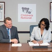 Michelle Riley-Brown, MHA, FACHE, president and CEO of Children’s National, signs the Epic contract