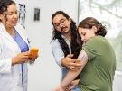 doctor showing family how to use a glucose monitor