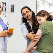 doctor showing family how to use a glucose monitor