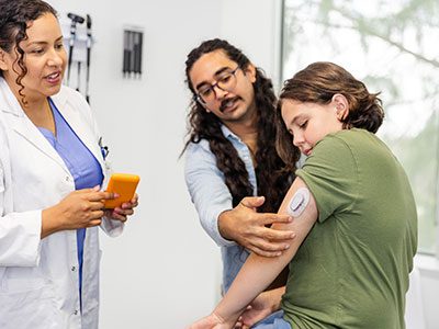 doctor showing family how to use a glucose monitor