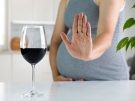 Pregnant woman saying no to a glass of wine.