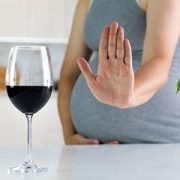 Pregnant woman saying no to a glass of wine.
