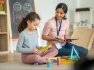 A psychiatrist watches as a child does play therapy