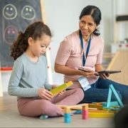 A psychiatrist watches as a child does play therapy