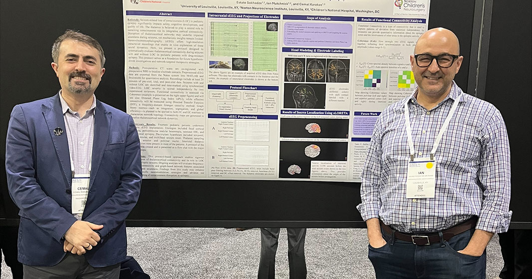 Dr. Cemal Karakas presents a research poster alongside fellow neurologist
