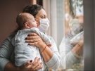 mom wearing mask and holding baby
