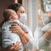 mom wearing mask and holding baby