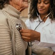 doctor listening to woman's heart with a stethoscope