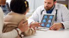 doctor showing brain scans to mom and daughter