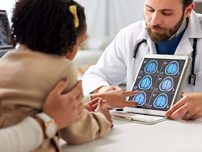 doctor showing brain scans to mom and daughter