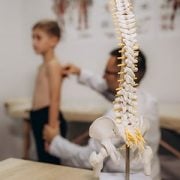 Doctor assessing a boy's spine